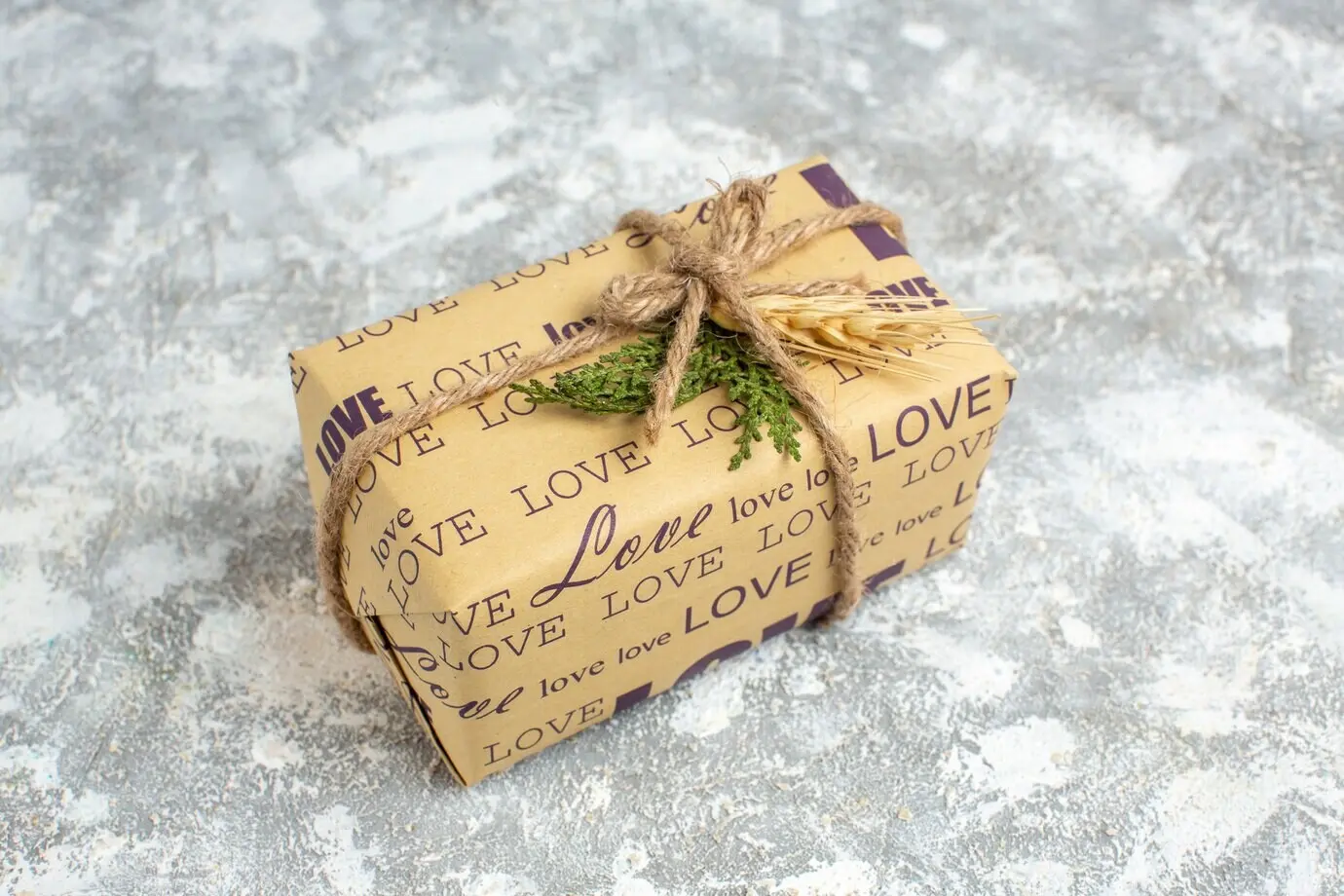 Overhead view of a beautiful Christmas-wrapped gift with a love inscription on an ice table.